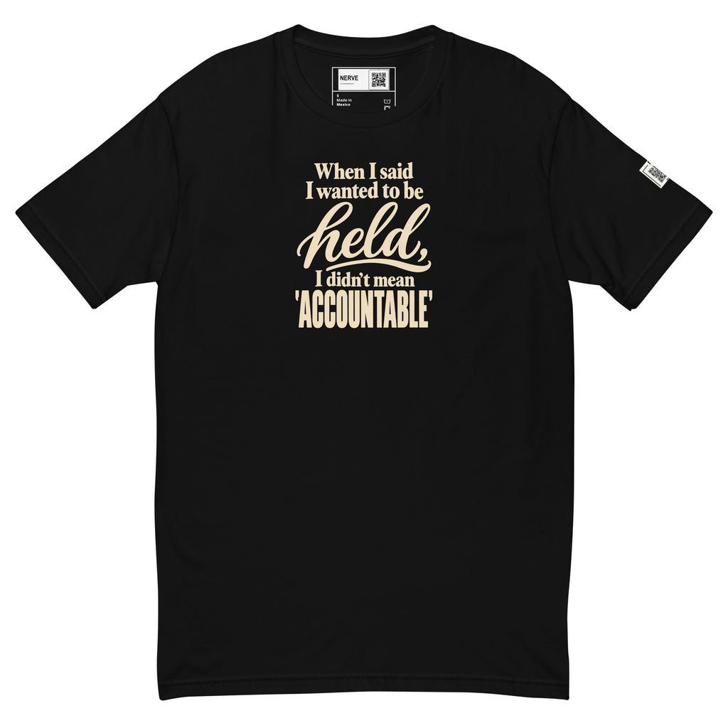 Black Held / Accountable graphic tee, front view with cream typography, inside label and left-sleeve QR code.