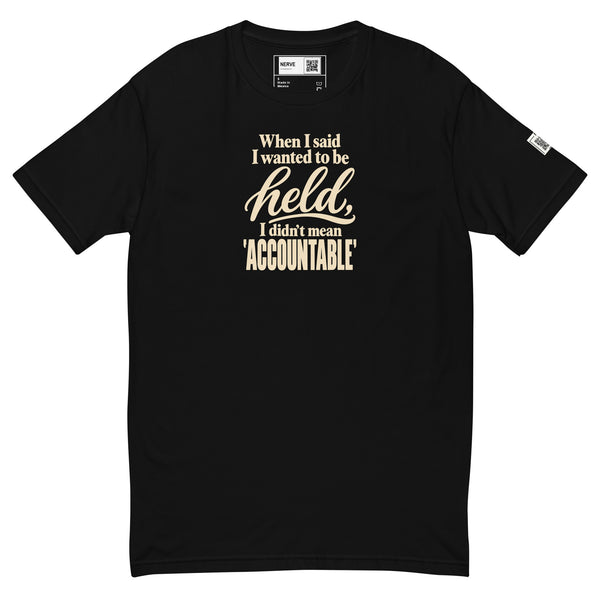 Black Held / Accountable graphic tee, front view with cream typography, inside label and left-sleeve QR code.