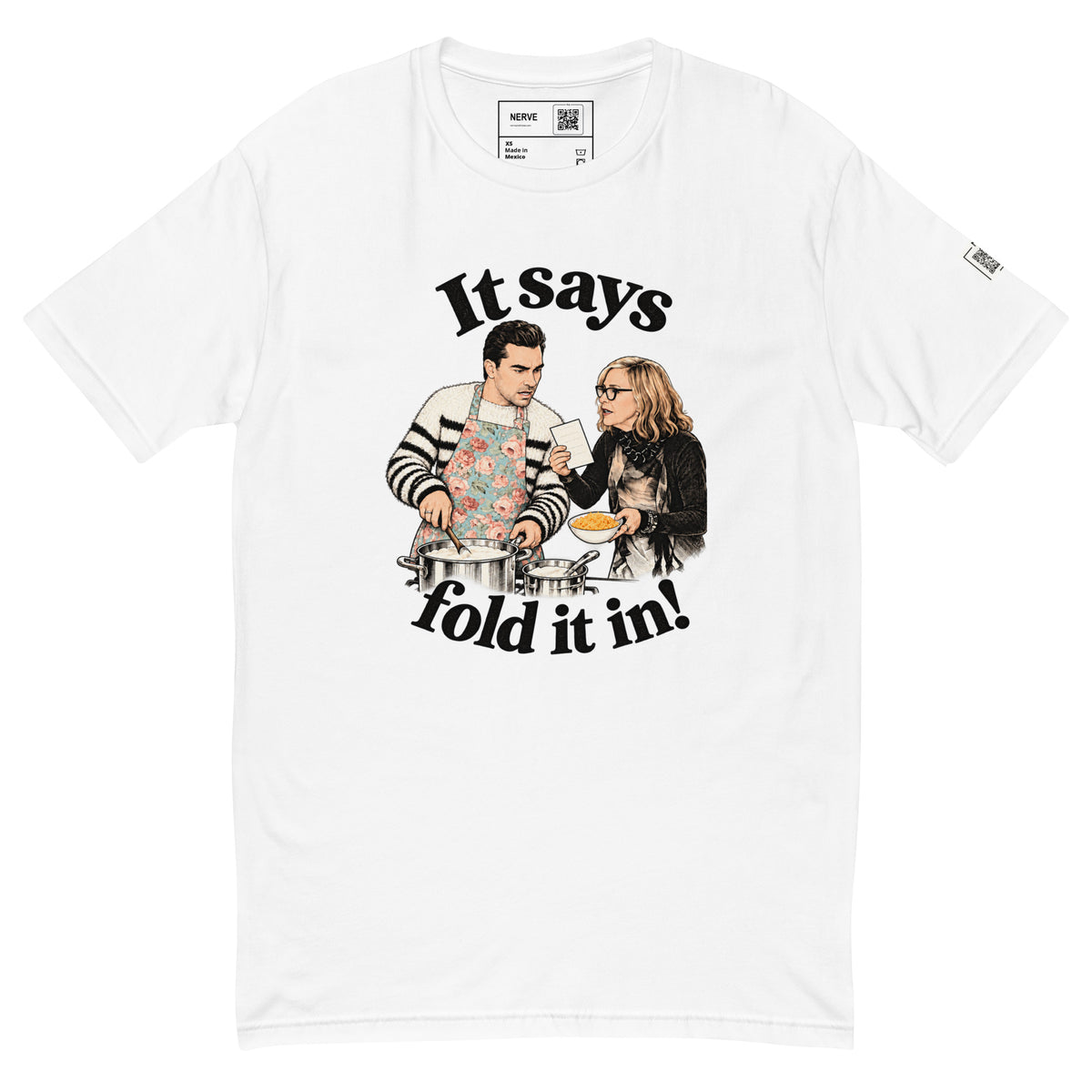 White short-sleeve tee with “It says fold it in!” lettering, a man stirring a pot and a woman holding a card and bowl.