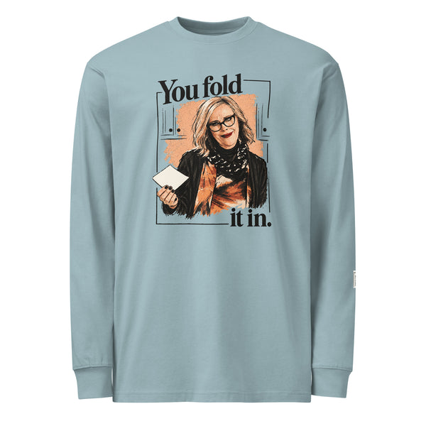 Agave long-sleeve tee with “You fold it in.” lettering and a woman in glasses holding a card.