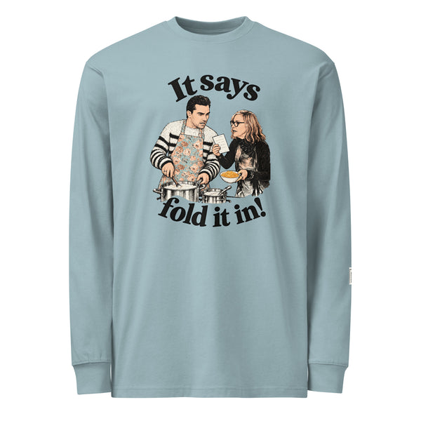 Agave long-sleeve tee with “It says fold it in!” lettering, a man in an apron stirring a pot and a woman holding a card and bowl.