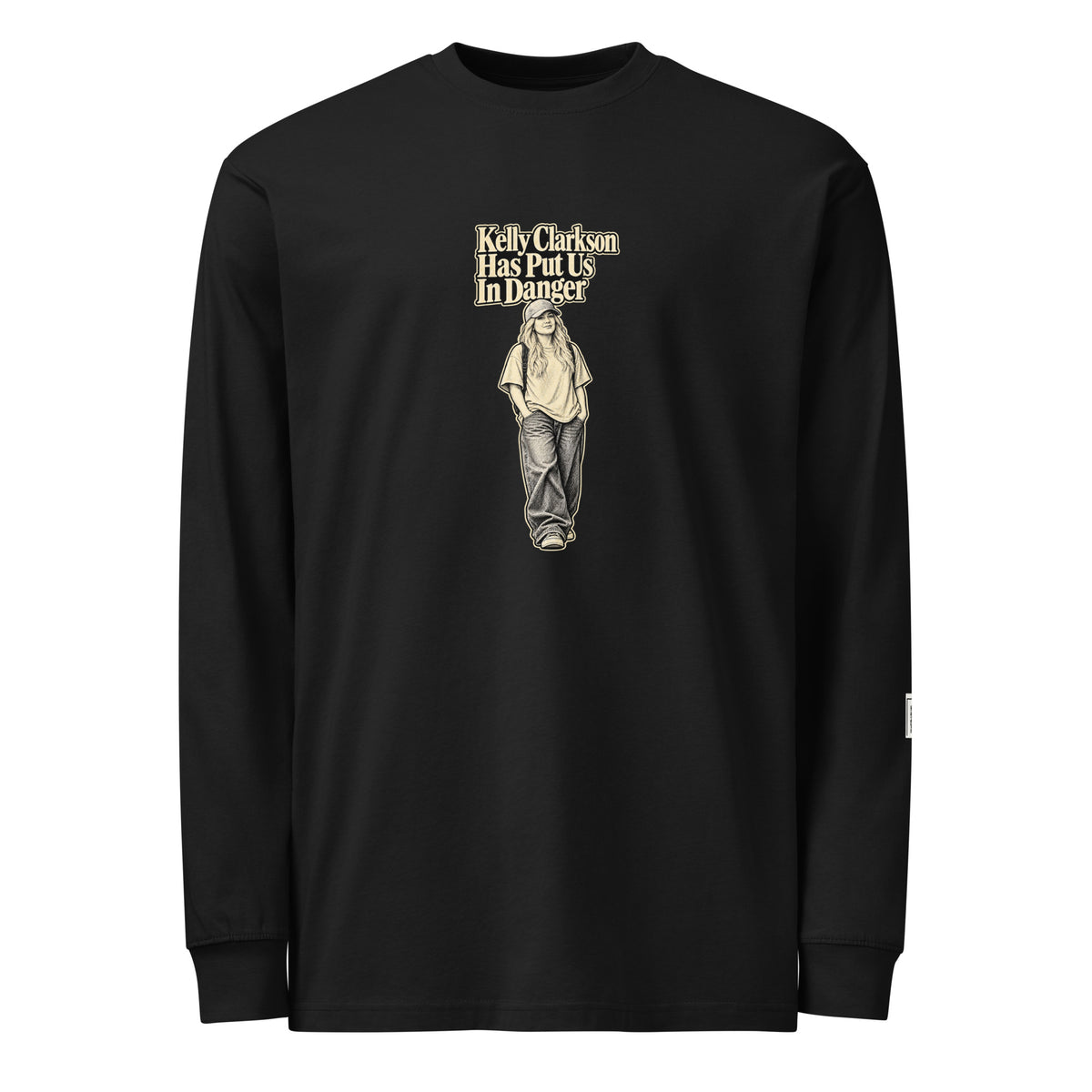 Black long-sleeve tee with “Kelly Clarkson Has Put Us In Danger!” lettering above a standing person in a cap.